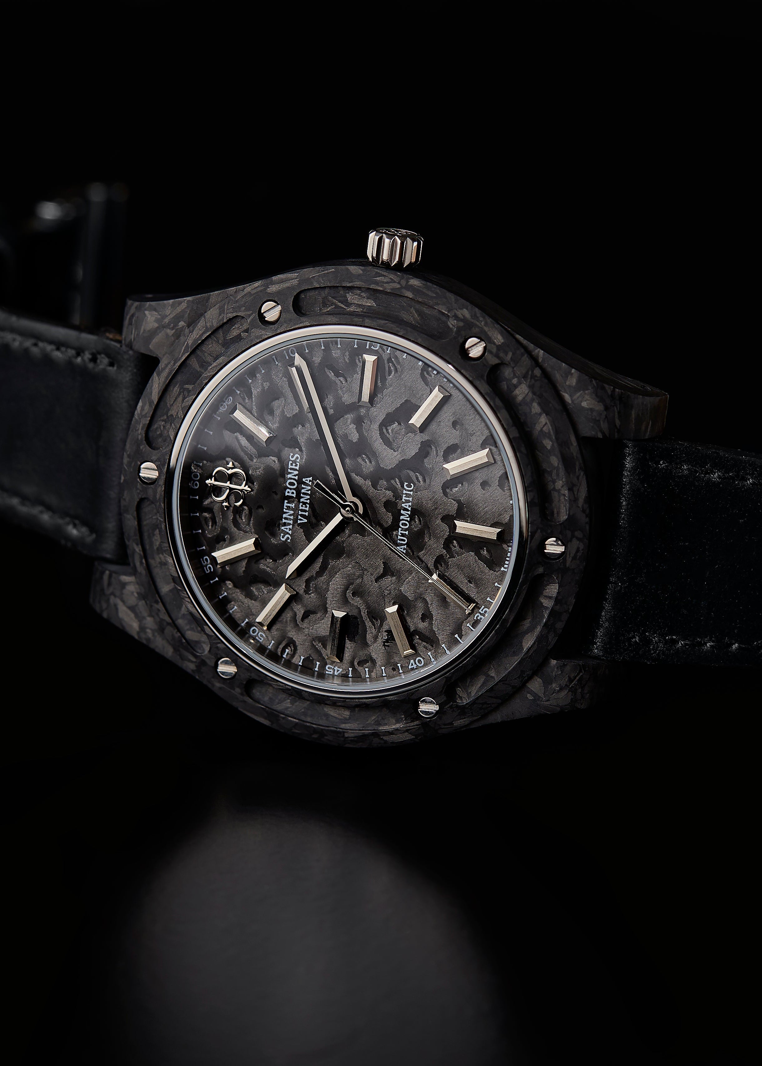 Black wristwatch with detailed face on a black background